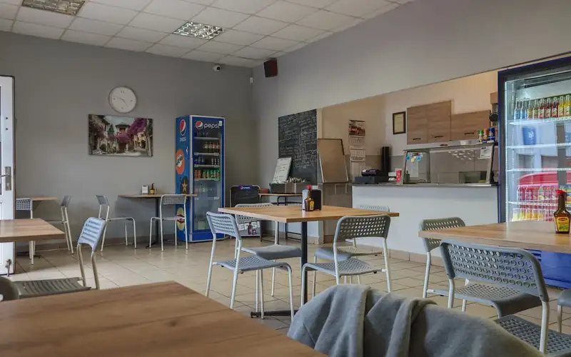 Jasna sala Bufetu ze stolikami i ladą